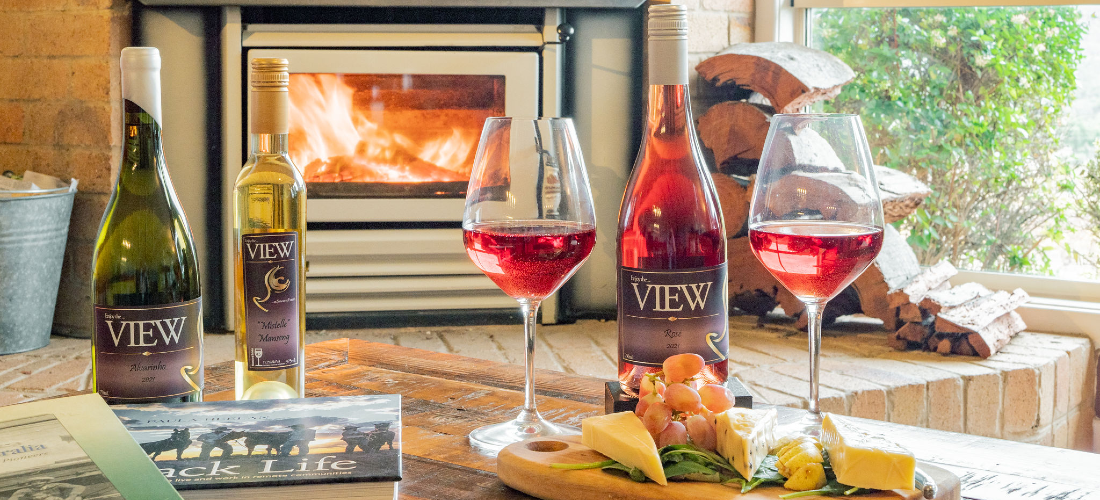 View Wine bottles, glases and cheese plate by the fireplace 